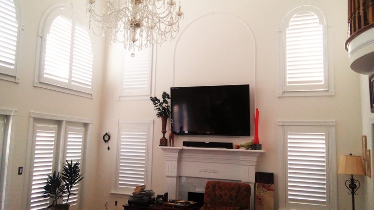 Fort Lauderdale great room with wall-mounted television and arched windows.